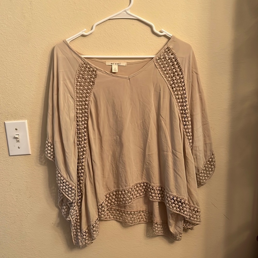 Between a poncho and crop top style shirt